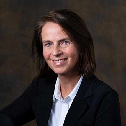 Portret van Linda Warmerdam van Happy Brain Clinics in professionele kleding tegen een donkere achtergrond.