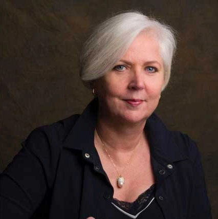 Portret van Happy Brain Coach Caro Botman tegen een donkere achtergrond.