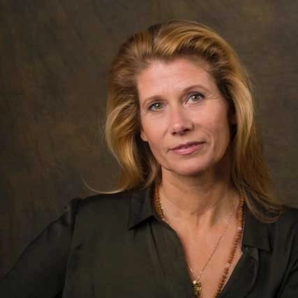 Portret van Caroline Schaay, Happy Brain Coach, voor een neutrale donkere achtergrond.