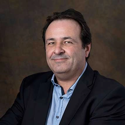 Portret van Pascal van Vlodrop van Happy Brain Clinics in een donker pak tegen een neutrale achtergrond.