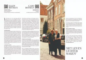 Twee vrouwen lopen arm in arm lachend over een zonovergoten klinkerstraat in een historische binnenstad.