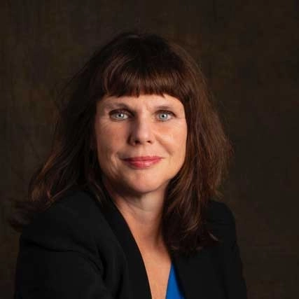 Portret van Suzanne Mijnheer van Happy Brain Clinics tegen een donkere achtergrond.
